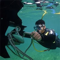 Hookah diver untangles boat propeller